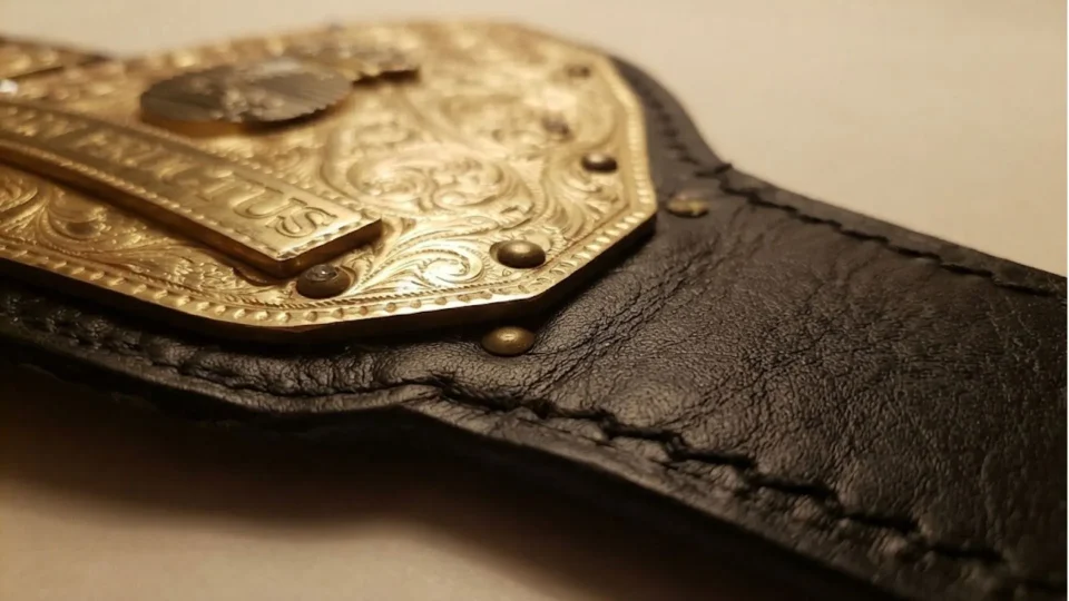 Close-up of handcrafted championship belt plate and leather stitching