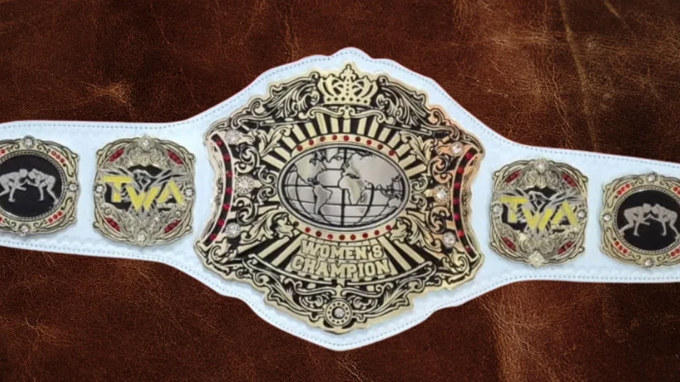 Close up of an etched championship belt plate showing the fine detail cut into the metal