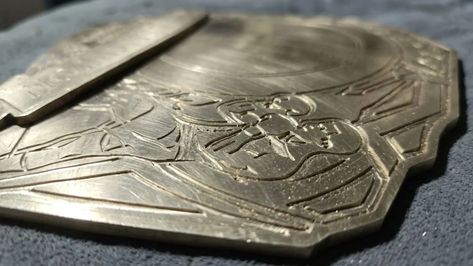 Etched brass championship belt plate before plating, showing the depth of the engraved design